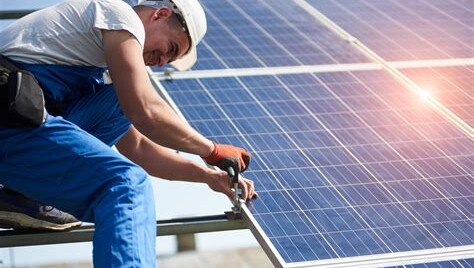 Homeowner shaking hands with solar installer in front of roof panels