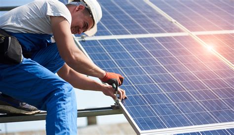 Homeowner shaking hands with solar installer in front of roof panels